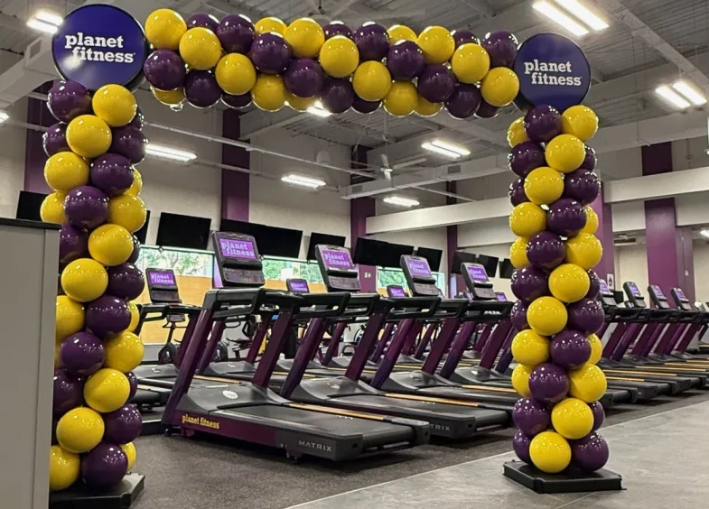 Arco BISAN morado y amarillo en Planet Fitness Macarena