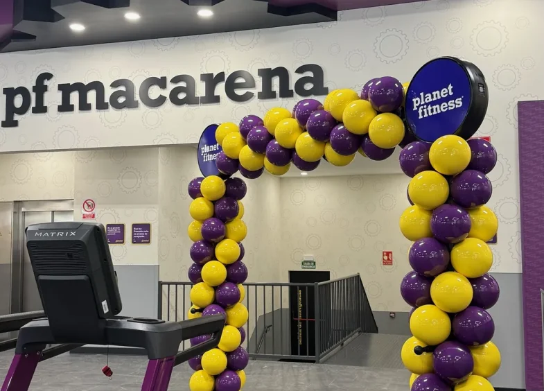 Arco BISAN morado y amarillo en Planet Fitness Macarena