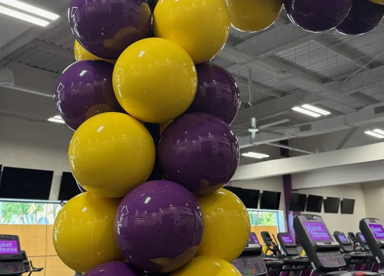 Arco BISAN morado y amarillo en Planet Fitness Macarena